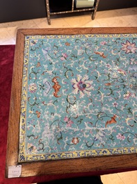 A Chinese famille rose turquoise-ground 'flower scrolls and bats' plaque, later mounted as table, Qianlong