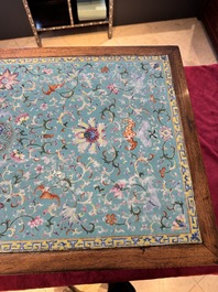A Chinese famille rose turquoise-ground 'flower scrolls and bats' plaque, later mounted as table, Qianlong