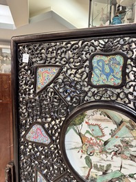 A large Chinese openworked wooden screen with famille verte and famille rose plaques, 18/19th C.