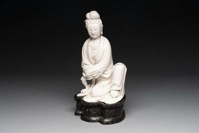 A rare and elegant Chinese Dehua blanc de Chine Guanyin on a wooden stand, Transitional period