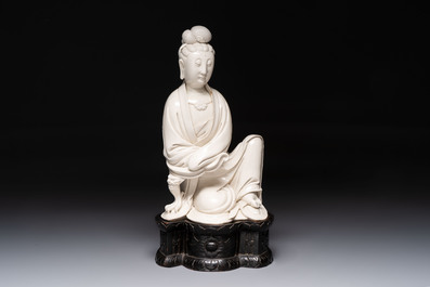 A rare and elegant Chinese Dehua blanc de Chine Guanyin on a wooden stand, Transitional period