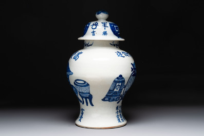 A Chinese blue and white vase and cover with calligraphy and antiquities, 19th C.