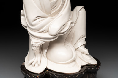 A rare and elegant Chinese Dehua blanc de Chine Guanyin on a wooden stand, Transitional period