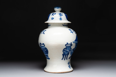 A Chinese blue and white vase and cover with calligraphy and antiquities, 19th C.