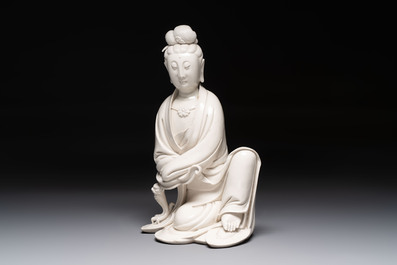 A rare and elegant Chinese Dehua blanc de Chine Guanyin on a wooden stand, Transitional period