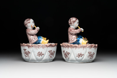 A pair of polychrome Dutch Delft fluting-children-topped butter tubs and covers, 18th C.