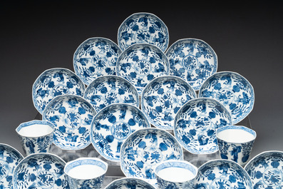 A collection of 18 Japanese blue and white cups and 17 saucers with figural and floral design, 19th C.