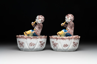 A pair of polychrome Dutch Delft fluting-children-topped butter tubs and covers, 18th C.