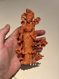 A Chinese red coral figure of a goddess on wooden stand, 19/20th C.