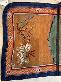 Two Tibetan saddle rugs with Buddhist lions and antiquities, 19th C.
