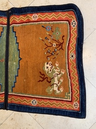 Two Tibetan saddle rugs with Buddhist lions and antiquities, 19th C.