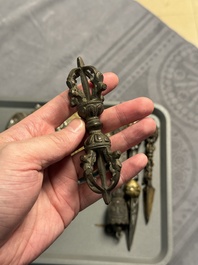 Four Tibetan bronze and wooden phurbas, a 'kapala' or skull-bowl and two silver ornaments, 19th C.