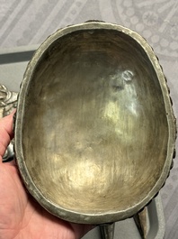 Four Tibetan bronze and wooden phurbas, a 'kapala' or skull-bowl and two silver ornaments, 19th C.