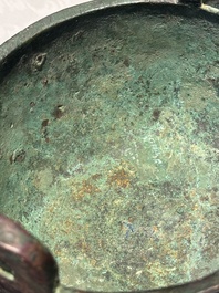 A Chinese archaic bronze tripod food vessel with 'taotie' design, 'ding 鼎', Western Zhou