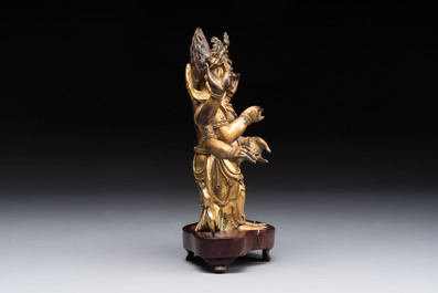 A Sino-Tibetan gilt-bronze figure of White Mahakala on wooden stand, 18th C.