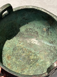 A Chinese archaic bronze tripod food vessel with 'taotie' design, 'ding 鼎', Western Zhou