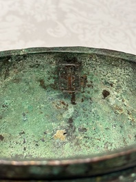 A Chinese archaic bronze tripod food vessel with 'taotie' design, 'ding 鼎', Western Zhou