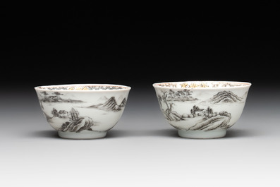 A pair of Chinese grisaille and iron-red 'landscape' cups and saucers, Yongzheng/Qianlong