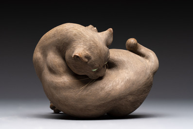 A Chinese Shiwan stoneware cat on a wooden stand, 20th C.