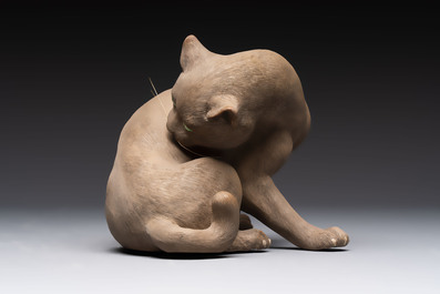 A Chinese Shiwan stoneware cat on a wooden stand, 20th C.