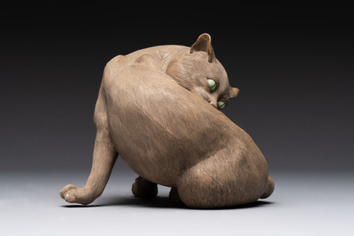 A Chinese Shiwan stoneware cat on a wooden stand, 20th C.