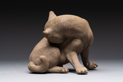 A Chinese Shiwan stoneware cat on a wooden stand, 20th C.