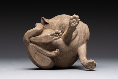 A Chinese Shiwan stoneware cat on a wooden stand, 20th C.