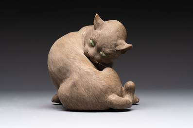 A Chinese Shiwan stoneware cat on a wooden stand, 20th C.
