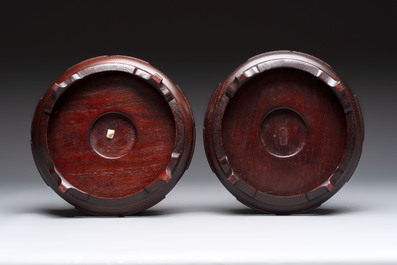 A pair of Chinese famille rose vases with narrative design on wooden stands, 19th C.