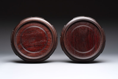 A pair of Chinese famille rose vases with narrative design on wooden stands, 19th C.