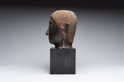 A large Thai bronze Shakyamuni Buddha head on wooden stand, Chieng Sen period, 16th C.