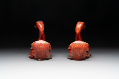 A pair of Chinese partly gilt coral-red-glazed models of ducks on wooden stands, 20th C.