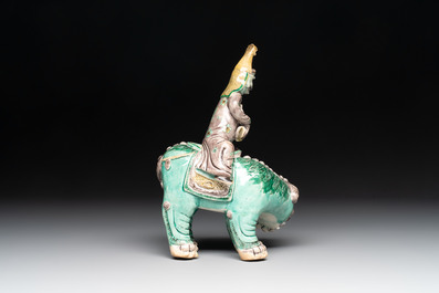 A Chinese verte biscuit 'Sogdian riding a Buddhist lion' group, 19th C.