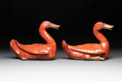 A pair of Chinese partly gilt coral-red-glazed models of ducks on wooden stands, 20th C.