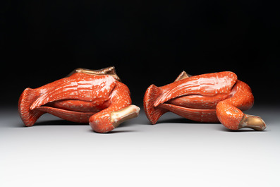 A pair of Chinese partly gilt coral-red-glazed models of ducks on wooden stands, 20th C.
