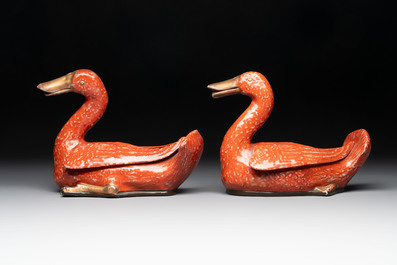A pair of Chinese partly gilt coral-red-glazed models of ducks on wooden stands, 20th C.