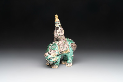 A Chinese verte biscuit 'Sogdian riding a Buddhist lion' group, 19th C.
