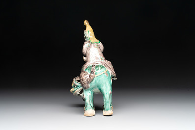 A Chinese verte biscuit 'Sogdian riding a Buddhist lion' group, 19th C.