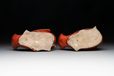 A pair of Chinese partly gilt coral-red-glazed models of ducks on wooden stands, 20th C.