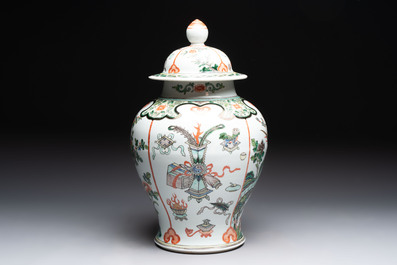 A Chinese famille verte covered vase, a pair of blue and white jars on wooden stands and two jars, 19th C.