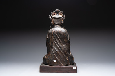 A large Chinese bronze Bodhisattva on wooden stand, Ming