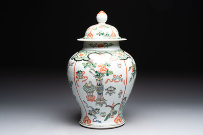 A Chinese famille verte covered vase, a pair of blue and white jars on wooden stands and two jars, 19th C.