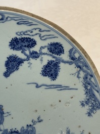 A Chinese blue and white circular plaque with two figures in a landscape, 19/20th C.