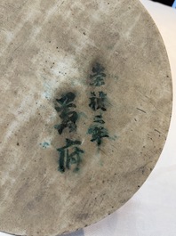A Chinese blue and white circular plaque with two figures in a landscape, 19/20th C.
