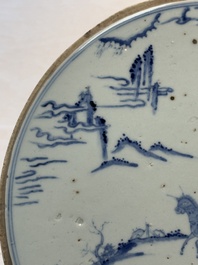 A Chinese blue and white circular plaque with two figures in a landscape, 19/20th C.