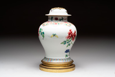 Three Chinese famille rose covered vases, one on a gilt bronze stand, and a covered jar, 19/20th C.