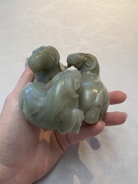 A Chinese celadon jade group of three goats on wooden stand, 19/20th C.