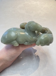 A Chinese celadon jade group of three goats on wooden stand, 19/20th C.