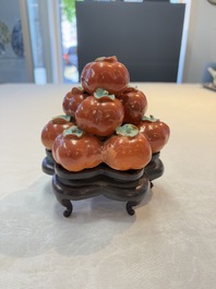 A pair of Chinese polychrome 'persimmons' groups on wooden stands, 19th C.