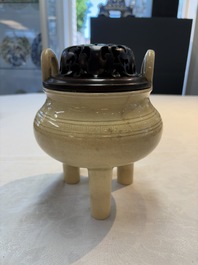 A Chinese Swatow cream-glazed tripod censer with wooden cover, 18/19th C.